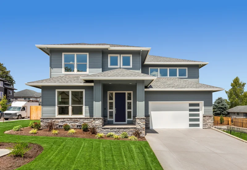 Modern home exterior painted in blue-gray with stone accents